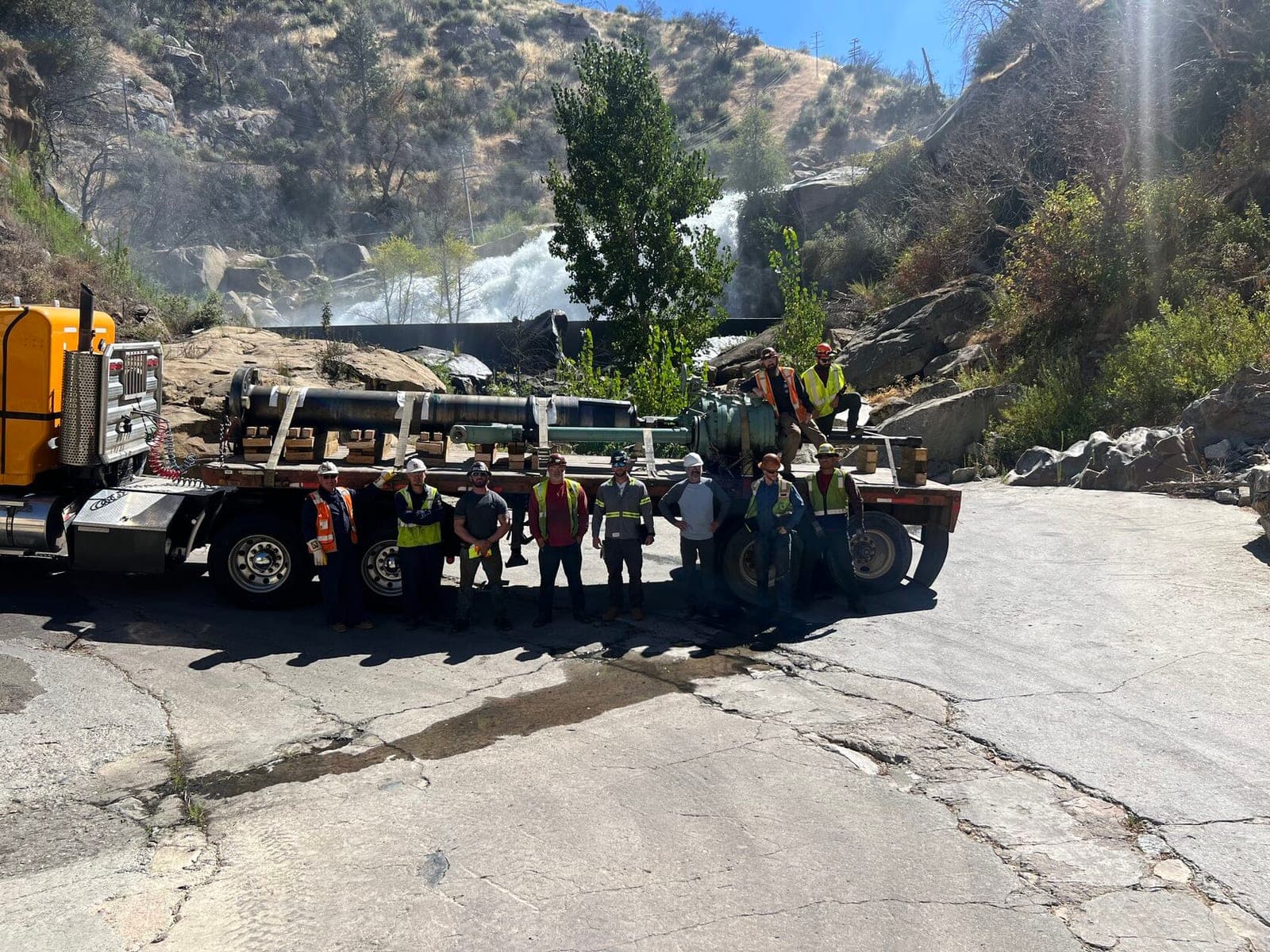 Craig Logistics crew with turbine shafts on a flatbed at a hydroelectric site